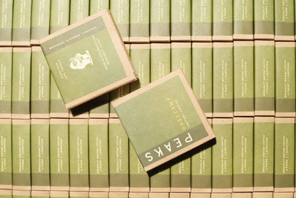 Stacks of green boxes with 'PEAKS' branding on a matching background
