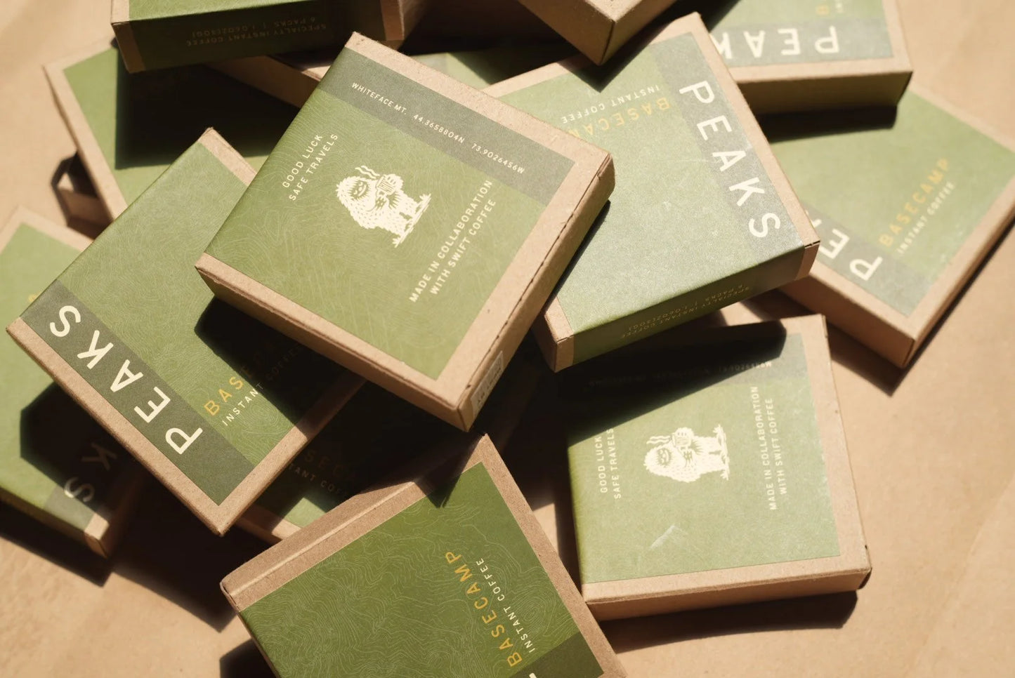 Stack of green boxes with 'Peaks' branding on a brown surface